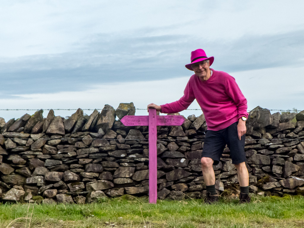 <center>2410-0010 - Chris and Pink signpost on the Dales Way -  October 13, 2024  <br>  (1/800 sec at f / 3.3 ISO 100    4.3 mm) </center>